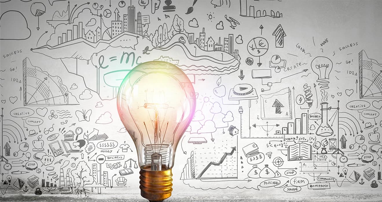 Incandescent light bulb with formulas, graphs and drawings on background wall