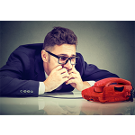 Man sits nervously looking at red phone awaiting phone interview for a job.